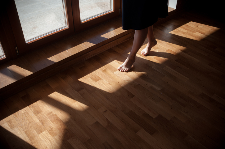 person tiptoeing on wooden floor