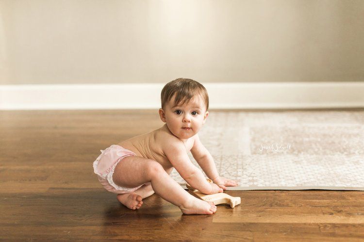 baby crawling on wooden floor 