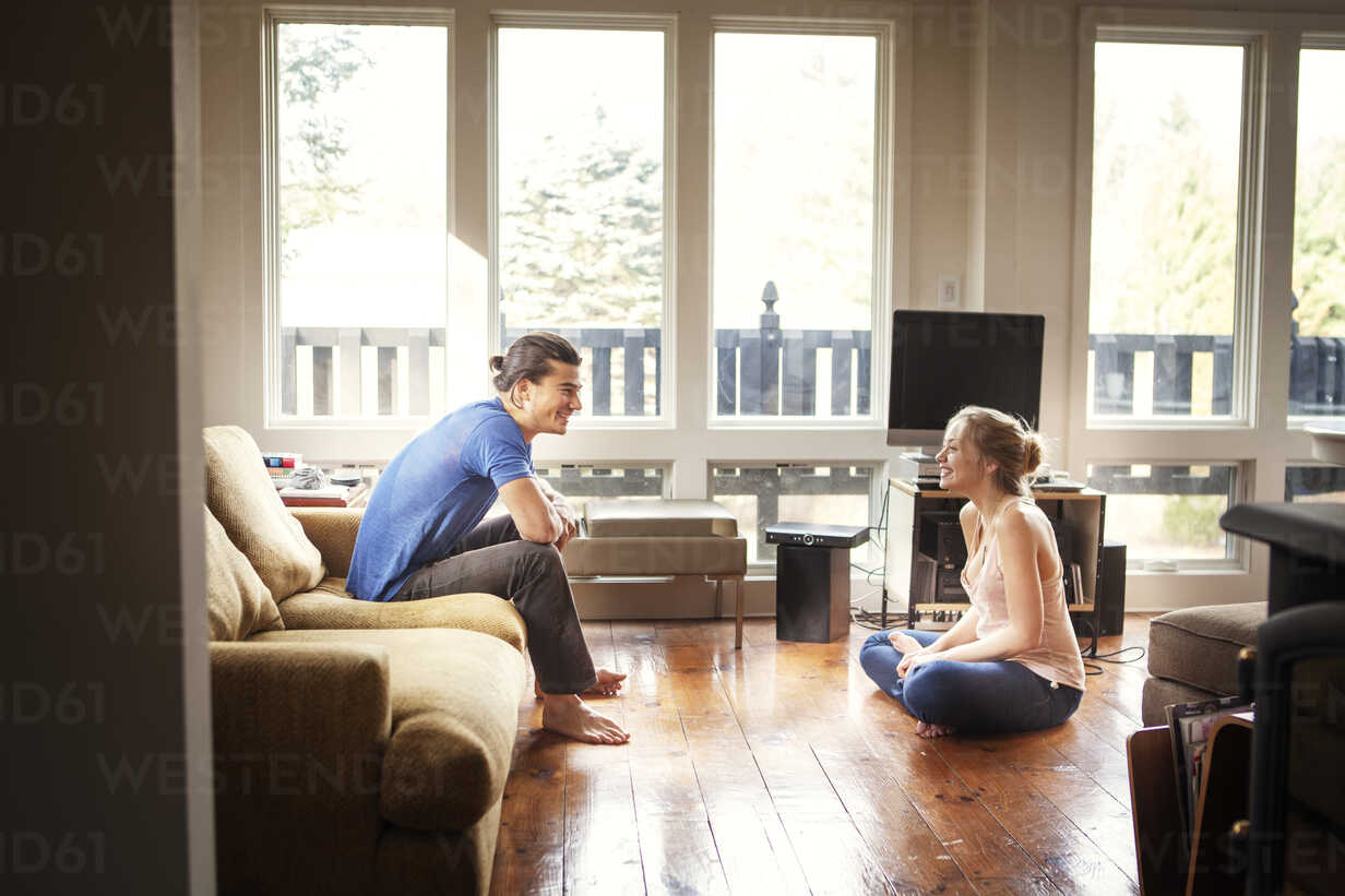 people talking while one person sits on wooden floor